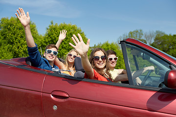 Image showing happy friends driving in cabriolet car at country