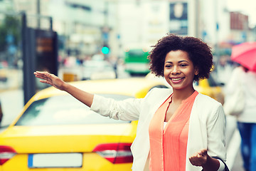 Image showing happy african woman catching taxi