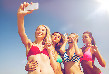 Image showing group of smiling women making selfie on beach