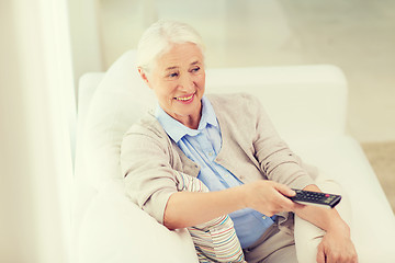 Image showing happy senior woman watching tv at home