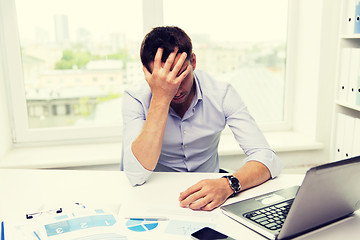 Image showing businessman with laptop and papers in office