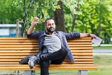 Image showing man with notebook or diary writing on city street