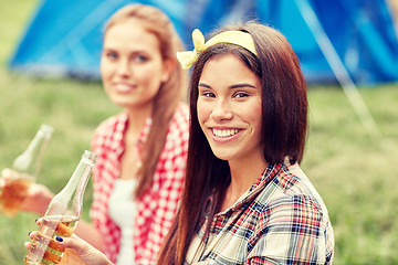 Image showing happy young women with tent and drinks at campsite