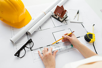 Image showing close up of hands with ruler measuring blueprint