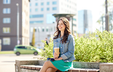 Image showing happy young woman drinking coffee on city street