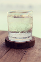 Image showing glass of water with ice cubes on table at beach