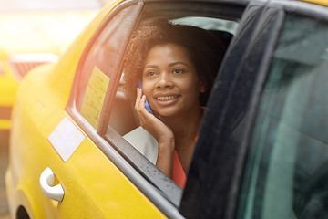 Image showing happy african woman calling on smartphone in taxi