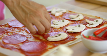 Image showing Woman making a delicious pepperoni pizza