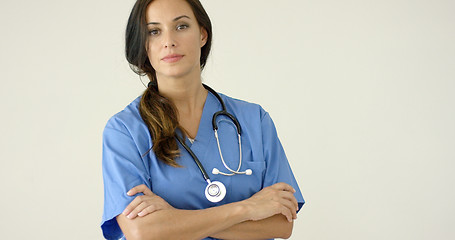 Image showing Woman in scrubs crosses arms and smiles at camera