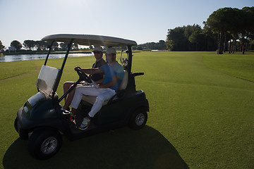 Image showing golf players driving cart at course