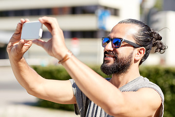 Image showing man taking video or selfie by smartphone in city