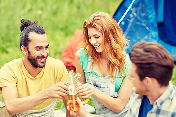 Image showing happy friends with tent and drinks at campsite