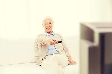 Image showing happy senior woman watching tv at home