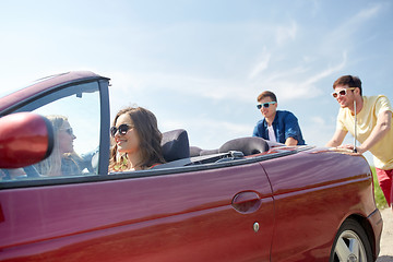 Image showing happy friends pushing broken cabriolet car