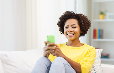 Image showing happy african woman with smartphone at home