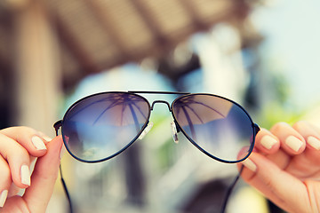 Image showing close up of hands holding shades or sunglasses