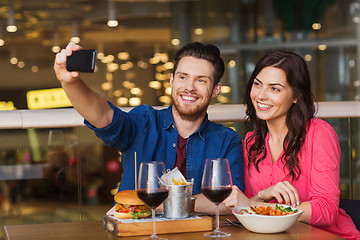 Image showing couple taking selfie by smartphone at restaurant