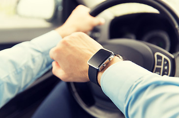 Image showing close up of man with wristwatch driving car