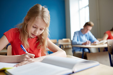 Image showing student girl with book writing school test