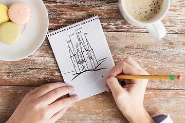 Image showing close up of hands drawing in notebook