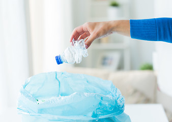 Image showing close up of hand and used bottles in rubbish bag