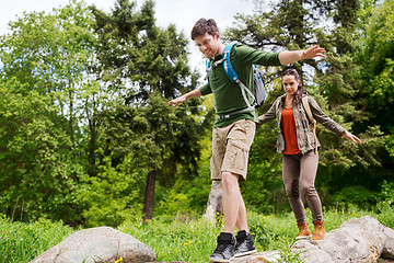 Image showing happy couple with backpacks hiking outdoors