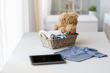 Image showing close up of baby clothes, toys and tablet pc