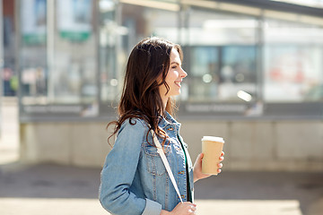 Image showing happy young woman drinking coffee on city street