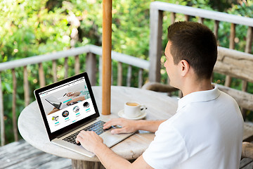 Image showing close up of man with online shop page on laptop