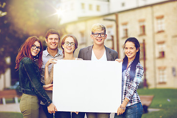 Image showing happy teenage students holding white blank board