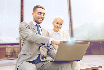 Image showing smiling businesspeople with laptop outdoors