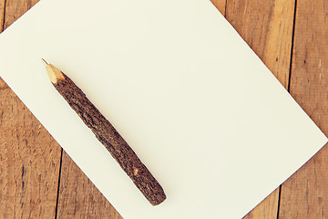 Image showing white blank paper sheet with wooden pen on table 