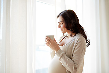 Image showing happy pregnant woman with cup drinking tea at home