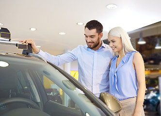 Image showing happy couple buying car in auto show or salon