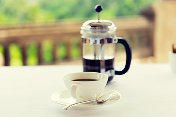 Image showing cup of coffee and french press on table 