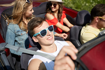 Image showing happy friends driving in cabriolet car