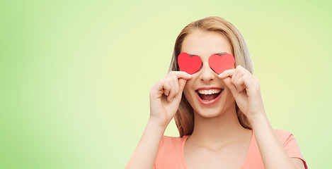 Image showing happy young woman with red heart shapes on eyes