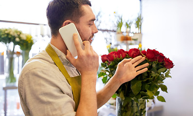 Image showing man with smartphone and red roses at flower shop