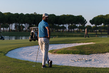 Image showing golfer from back at course looking to hole in distance