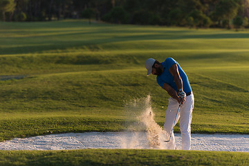 Image showing golfer hitting a sand bunker shot on sunset