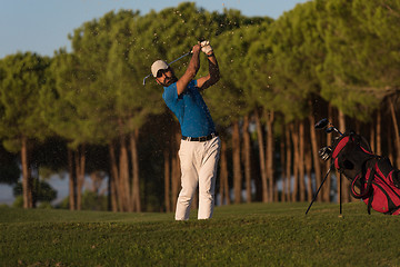 Image showing golfer hitting a sand bunker shot on sunset