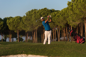 Image showing golfer hitting a sand bunker shot on sunset