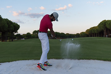 Image showing golfer hitting a sand bunker shot on sunset