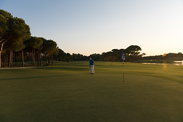 Image showing golfer hitting ball to hole