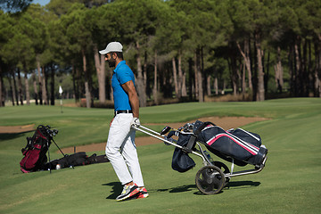 Image showing golf player walking with wheel bag