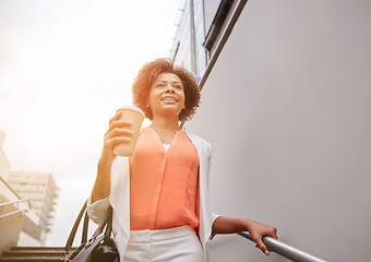 Image showing happy african businesswoman with coffee in city