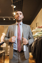 Image showing young man trying suit at clothing store