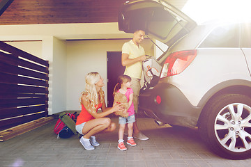 Image showing happy family packing things to car at home parking