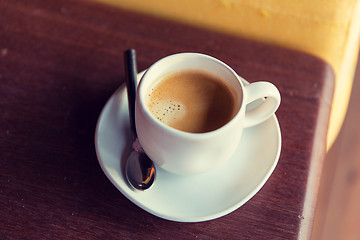 Image showing cup of black coffee with spoon and saucer on table