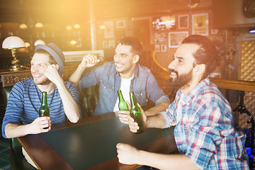 Image showing happy male friends drinking beer at bar or pub